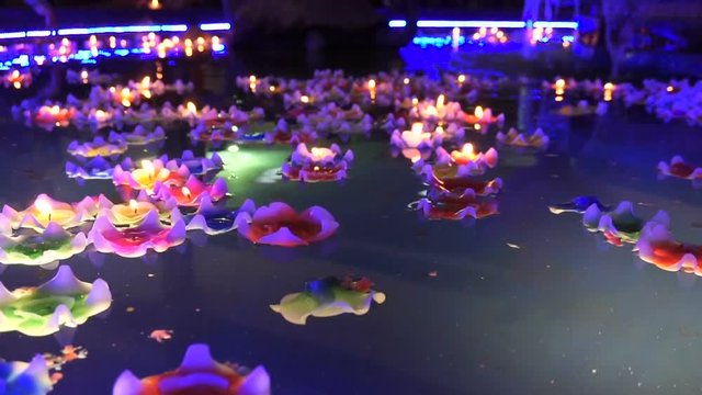 flower-shaped candle burning in the spirit pool of chinese temple
