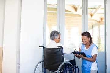 Disability senior woman discussing with female doctor