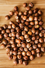 Plenty of organic hazelnuts on wooden cutting board