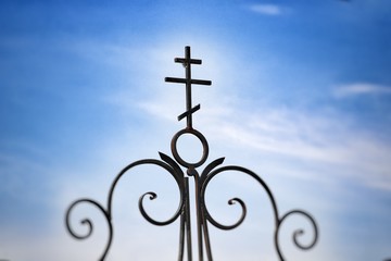 Forged cross on the gate, close-up