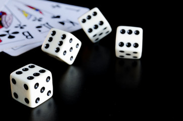Dice, playing cards on a black background