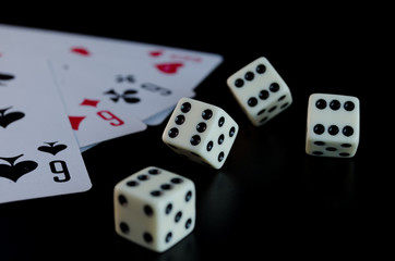 Dice, playing cards on a black background