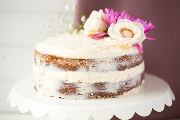 White Wedding Naked Cake in Rustic Style with White and Pink Flowers on the White Background