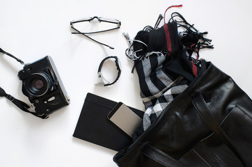 Сумка, фотоаппарат, блокнот, очки, часы, шарф смартфон на белом фоне, раскладка, вид сверху