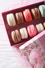 set of macaroons in a pink gift box close-up on a table. Vertical top view