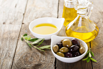 Olive oil in bottles and a bowl with olives