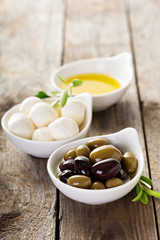 Olive oil, olives and mozzarella in bowls