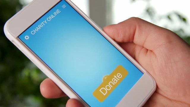 Man making an online donation using charity applicaiton on smartphone