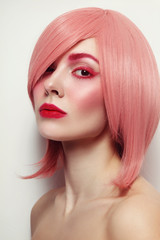 Portrait of young beautiful woman in pink wig