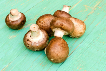 Mushrooms сhampignon lie in a heap on a blue wooden background.
