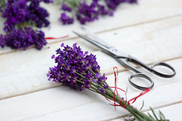 bunch of lavender on a white table with scissors on the side 