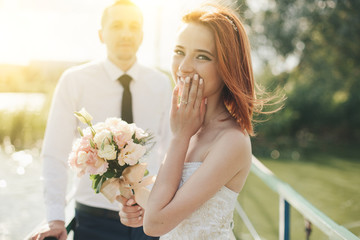 bride and groom are standing on the bridge