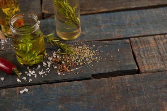 Spices by herb with oil in container on table