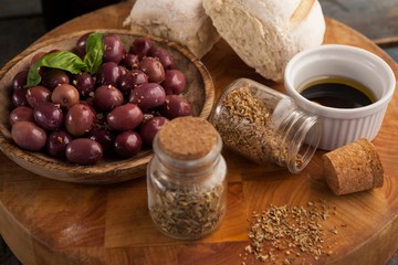 High angle view of spices by black olives in plate