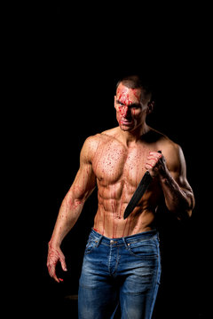 scary fitness muscular male model covered in blood with knife