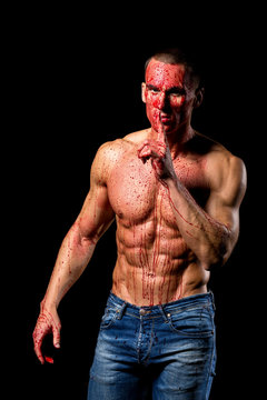 scary fitness muscular male model covered in blood with knife