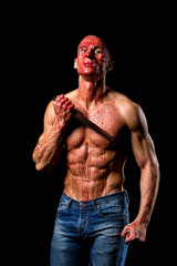 scary fitness muscular male model covered in blood with knife