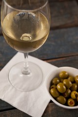 Close up of white wine by green olives served in container