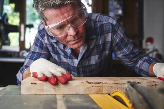 A Man Making A Precise Cut On A Table Saw