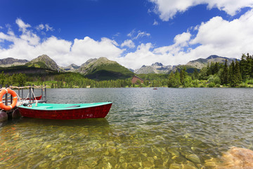 Fototapeta na wymiar Panorama mountain lake Strbske Pleso in the Tatra mountains. Summers colors and boat for swimming.