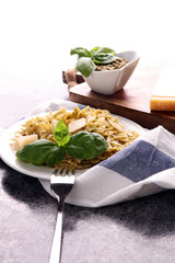 Farfalle pasta bows with pesto on a plate on a rustic background