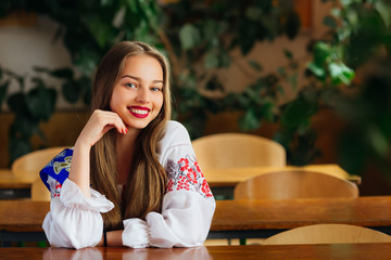 Pretty teen with beautiful smile and red lips sitting in the cla