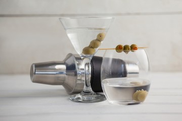 Green olives in vodka martini with cocktail shaker