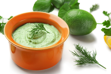 Delicious yogurt sauce in bowl with ingredients on white background