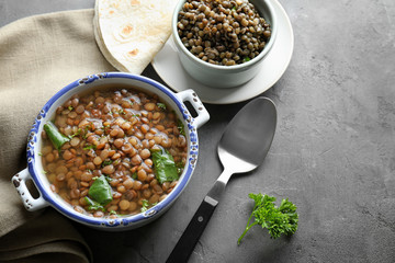 Composition with tasty lentil dish on grey table