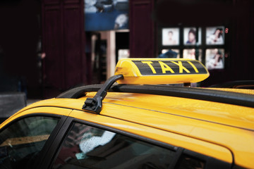 Taxi sign on yellow car roof, closeup