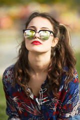 Portrait of cool young woman with sunglasses and red lipstick