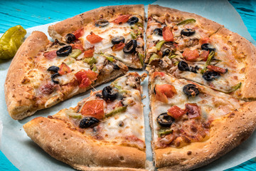 Vegetarian pizza with vegetables on blue table.