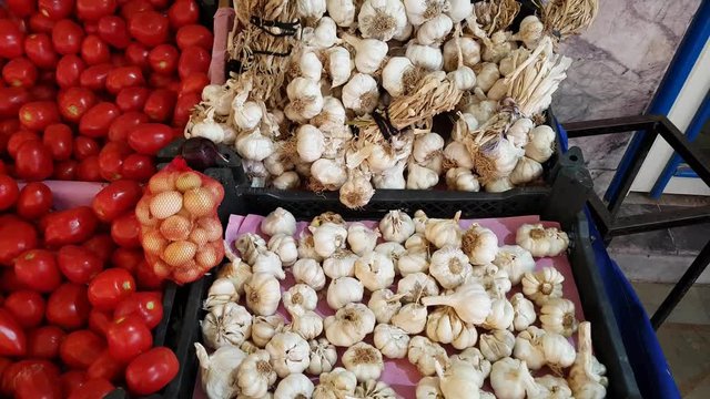 Fresh garlic and tomato for sale in a market.