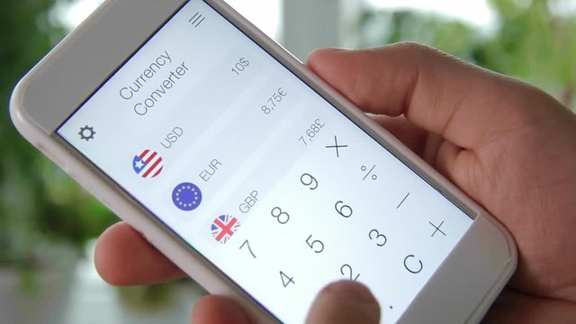 Using currency converter app on the smartphone - Powered by Adobe