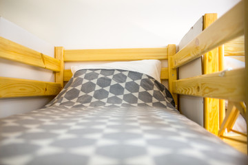 Interior of the hostel bedroom. Hostel with wooden bunk beds - obrazy, fototapety, plakaty