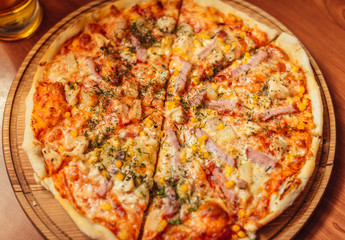 Hot pizza slice with melting cheese on a rustic wooden table.