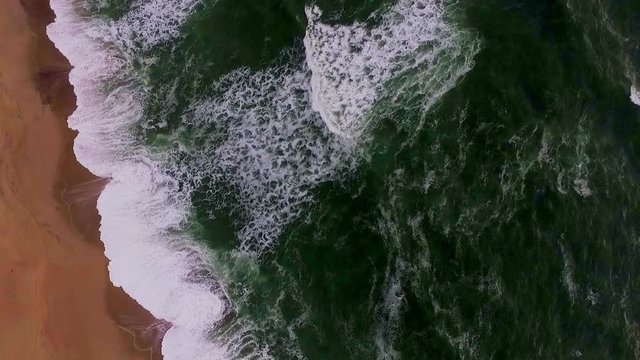 Beautiful large waves arrive on the sandy beach of Africa.