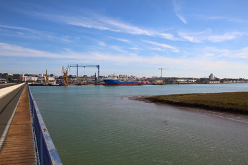 Beautiful landscape of  cranes in shipyard against a backlight in coast of Huelva, Andalusia, Spain.