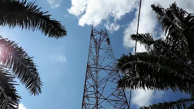a timelapse or hyperlapse of 3 erectors or riggers working at height for installation of tower members for telecommunication projecct.