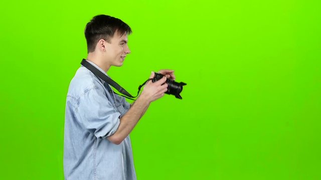 Guy takes pictures of the landscapes on the professional camera. Green screen. Slow motion