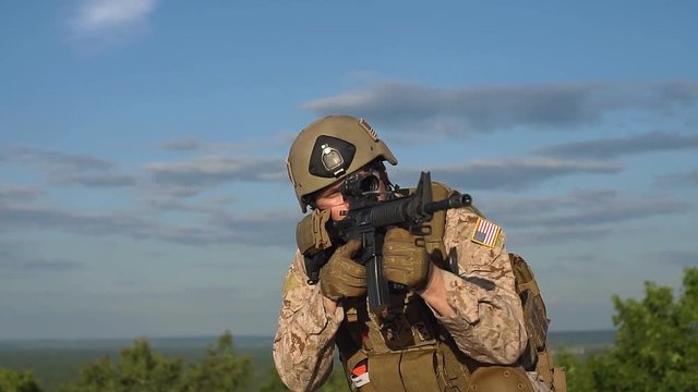 Slow motion. Man in military uniform with a gun shooting