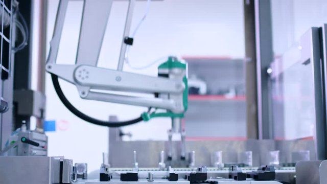 Medicine package on conveyor belt at pharmaceutical factory. Automated packaging line at pharmaceutical plant. Pharmaceutical manufacturing line. Packing machine. Modern technology. Robot arm