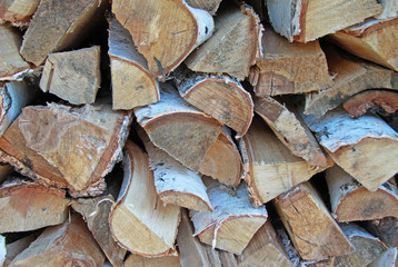 Chopped and stacked birch firewood as a background