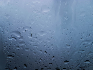 raindrop on the front car mirror with cloudy dark sky.