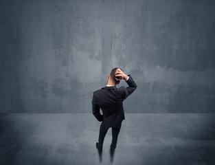 Businessman standing in front of urban wall