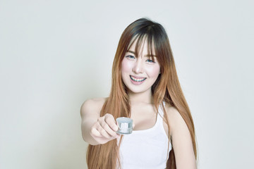 Asian woman holding white whitening cream bottles