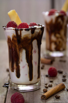 Delicious milkshake with ice cream, raspberries, chocolate, cinnamon and coffee beans
