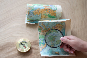 Map and compass lying on the wooden background