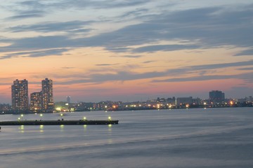 Urban Landscape around bay waters with moving clouds at dusk in horizontal frame