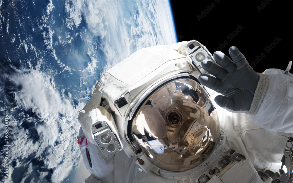 Canvas Prints astronaut in orbit of planet earth waving into the camera